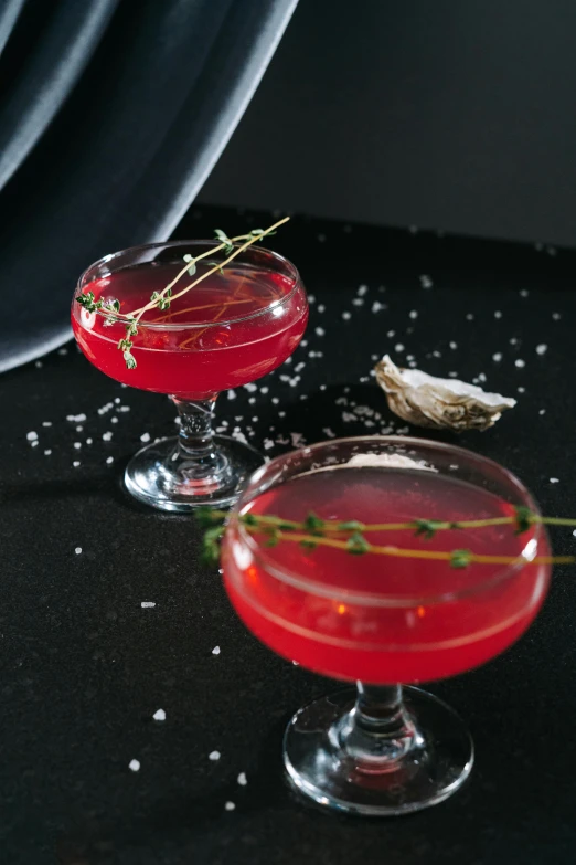 a red drink with sprigs on the edge