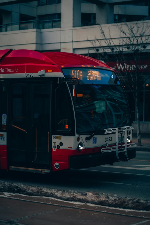 a red and white bus on a city street