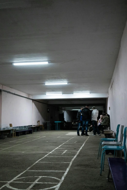 a group of people walking down a hallway, by Elsa Bleda, light and space, soviet yard, in the middle of an arena, lecture halls and gambling dens, completely empty