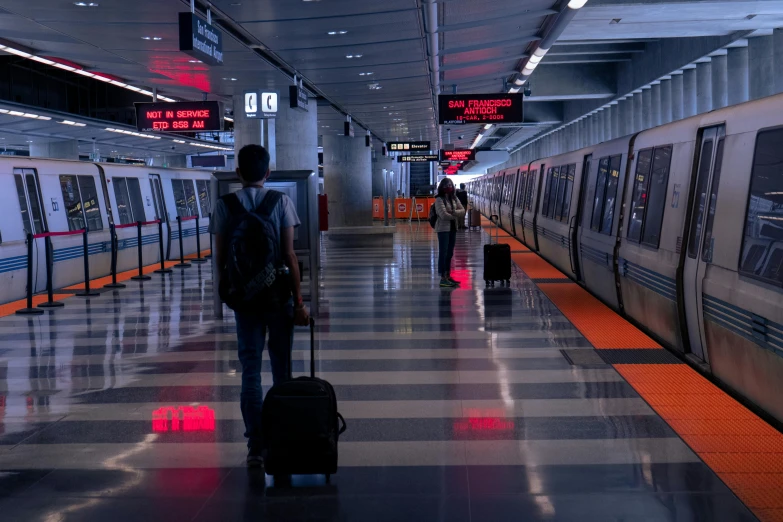 a man with a suitcase walking through a train station, by Carey Morris, unsplash contest winner, orange line, bay area, covid, avatar image