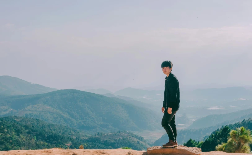 a man standing on top of a large rock, by Simon Gaon, pexels contest winner, realism, male ulzzang, panoramic view of girl, cai xukun, slightly pixelated