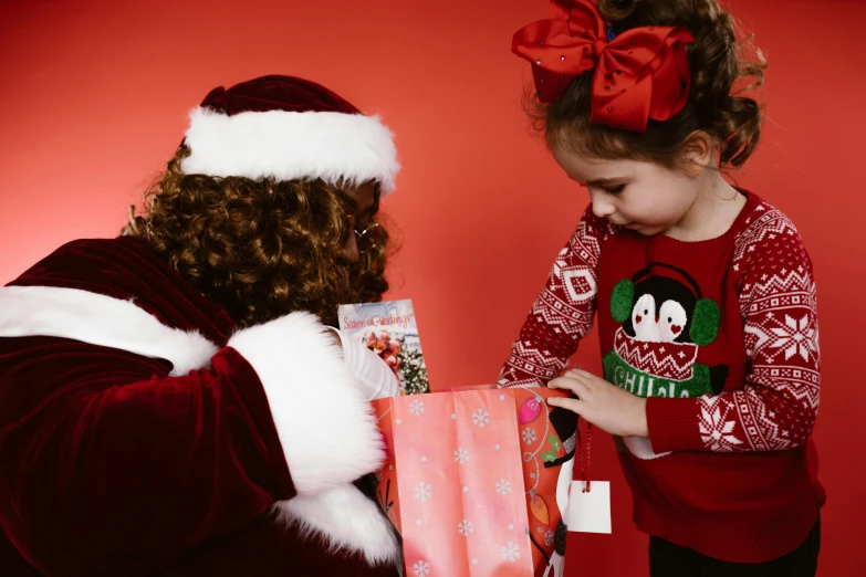 a small girl standing next to a christmas elf