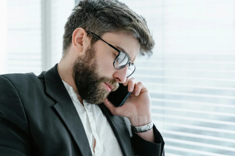 man in suit and glasses talking on the phone