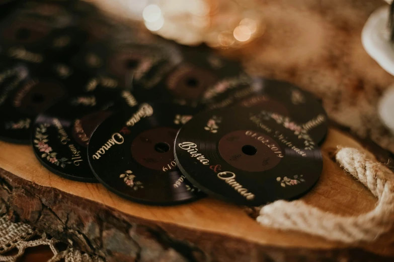 a bunch of buttons sitting on top of a wooden table, an album cover, by Emma Andijewska, unsplash, etched inscriptions, yennefer, wedding, black