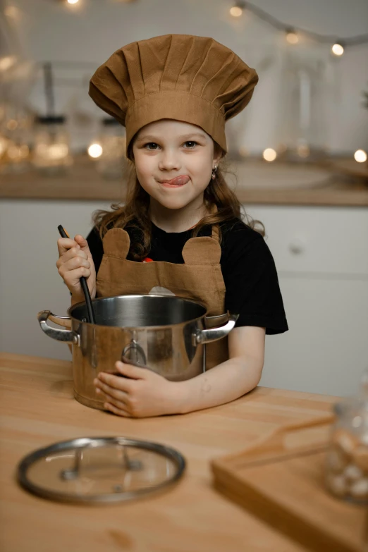 a little girl wearing a chef's hat in a kitchen, pexels contest winner, metal kitchen utensils, casual pose, brown, gif