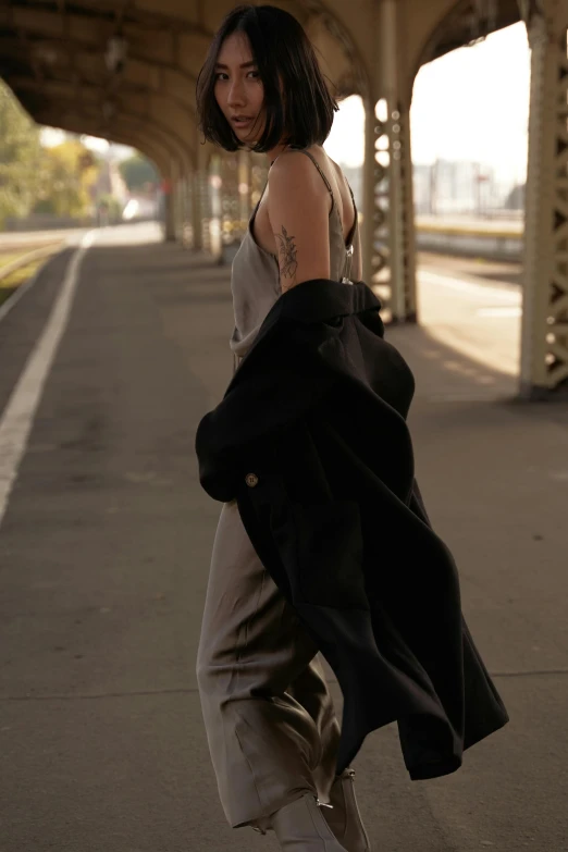 a woman in black jacket standing by the street