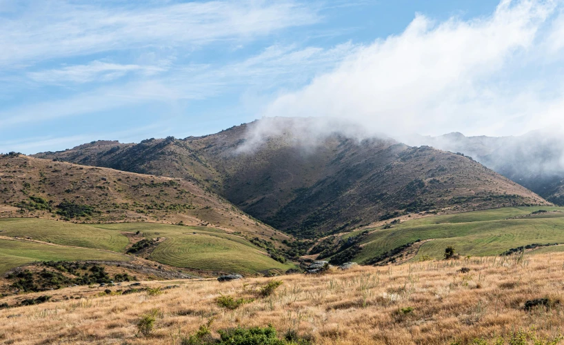 the clouds have blown over the rolling mountains