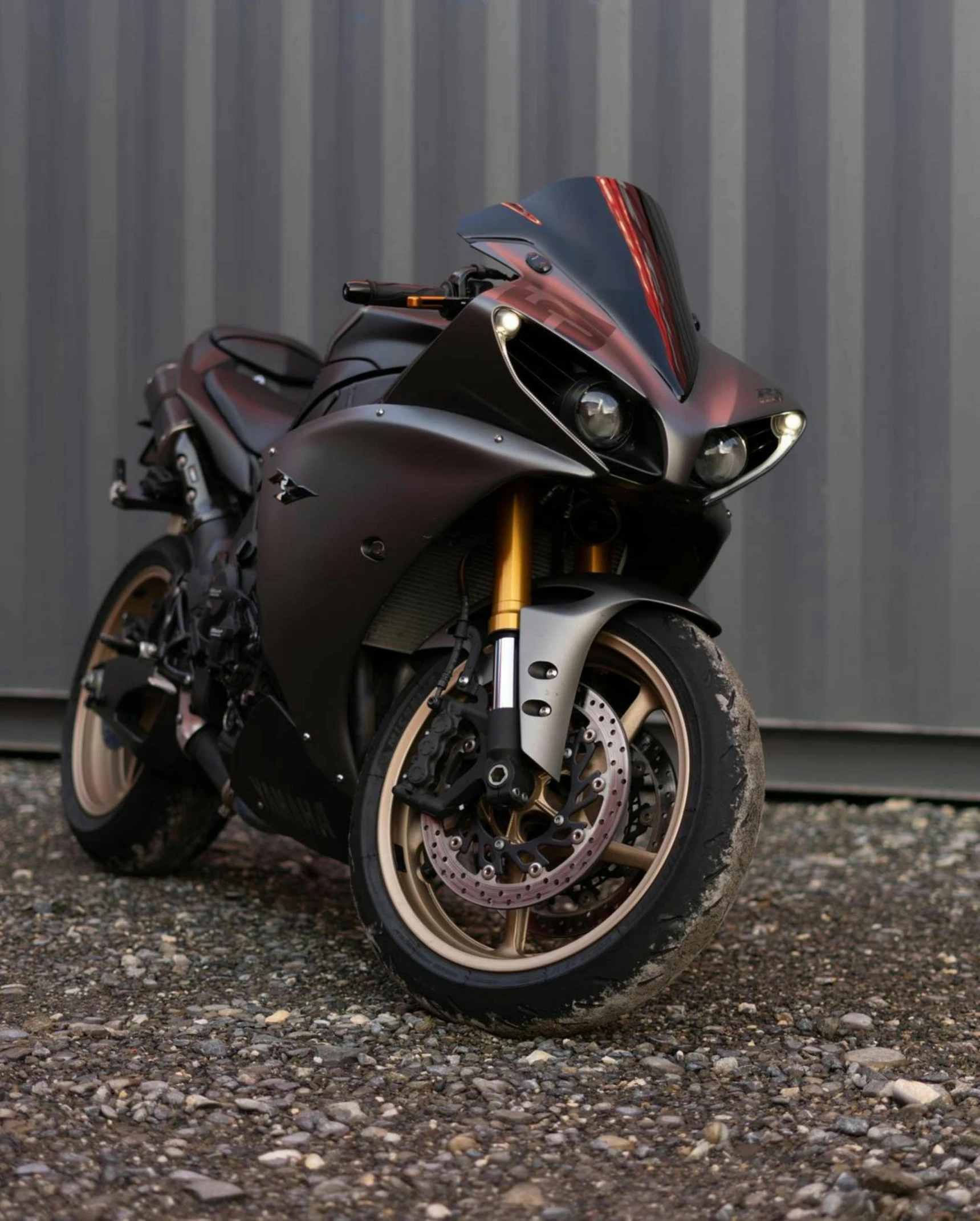 a black motorcycle parked in front of a building, brushed rose gold car paint, gradient brown to red, or black, brown resin