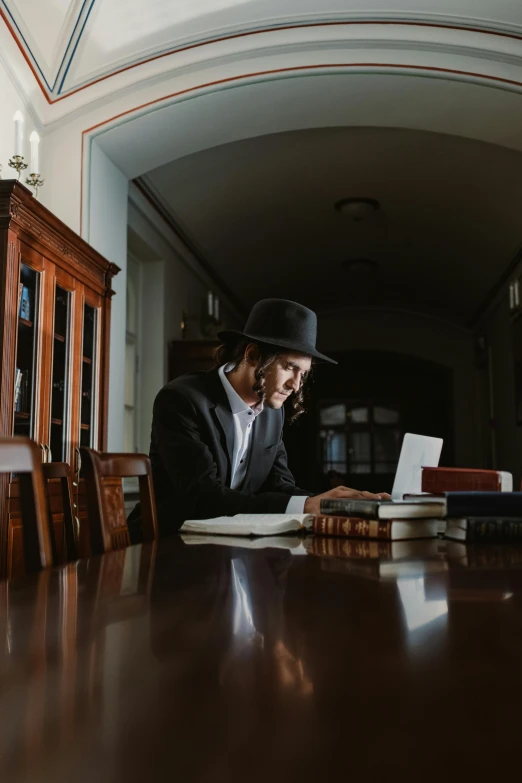 a man is looking at a book while using a cell phone