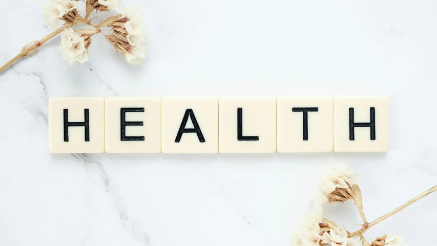 a wooden block with the word health written on it, by Elaine Hamilton, unsplash, realism, relaxed. gold background, white bg, bereal, sans
