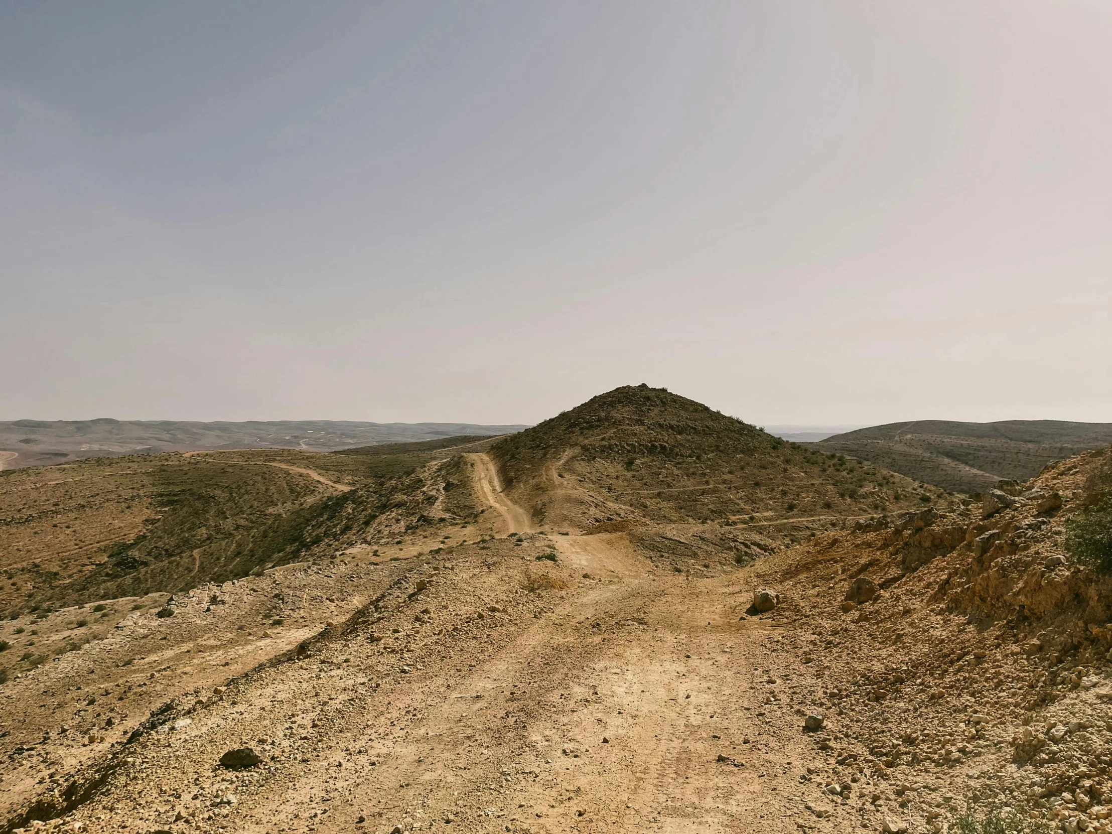 a dirt road surrounded by large mountains