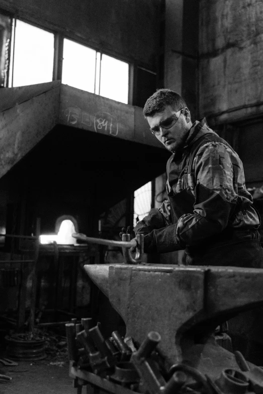 a black and white photo of a man working on an anvil, inspired by Václav Brožík, david boreanaz as chris redfield, steel mill, фото девушка курит, glass