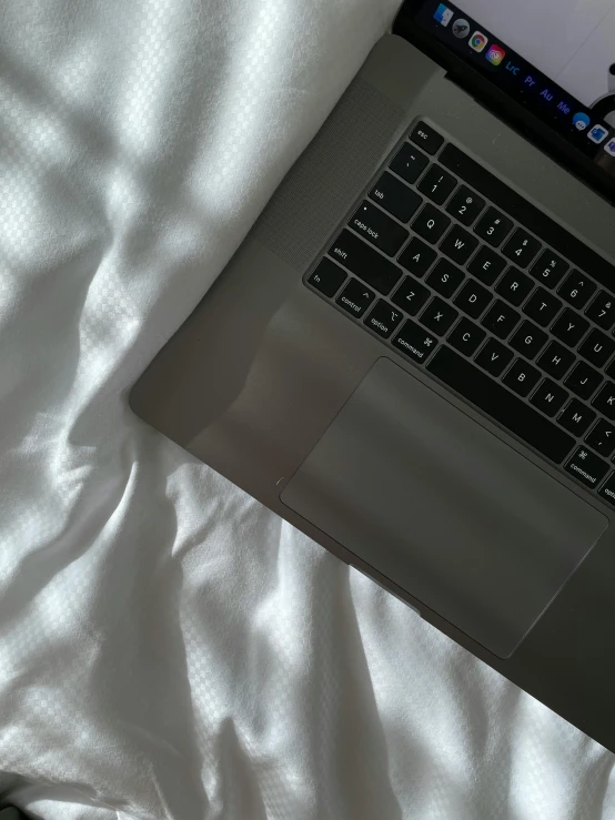 a laptop computer sitting on top of a bed, by Carey Morris, pearlescent skin, trending on vsco, close - up photograph, gray skin