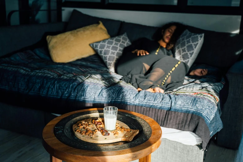 the woman lays on a couch with her stomach exposed while she sleeps in bed