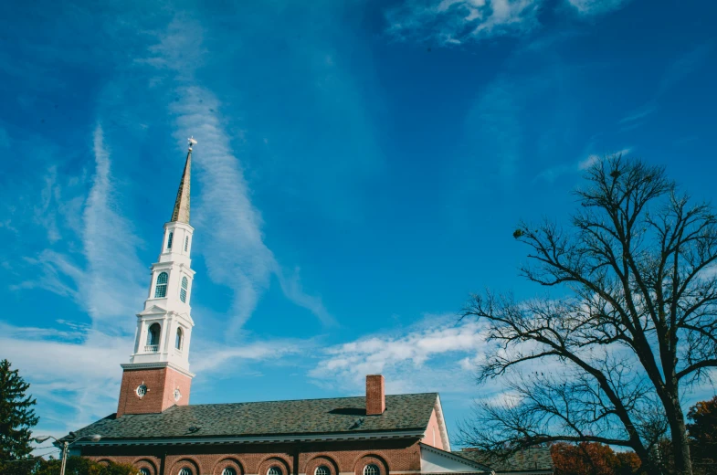 a church with a steeple against a blue sky, by Carey Morris, unsplash, happening, new england architecture, chesterfield, slide show, wide high angle view