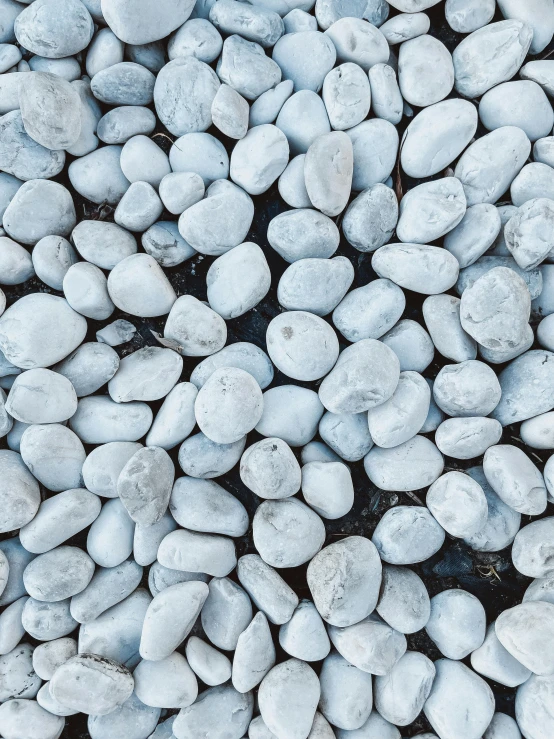 a pile of white rocks sitting on top of a black ground, an album cover, unsplash, blue gray, ((rocks)), beans, background image