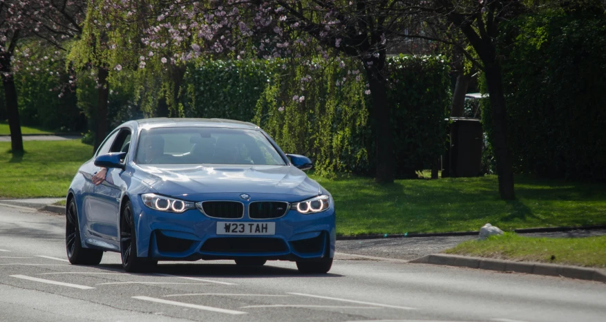 a blue bmw car driving down the street