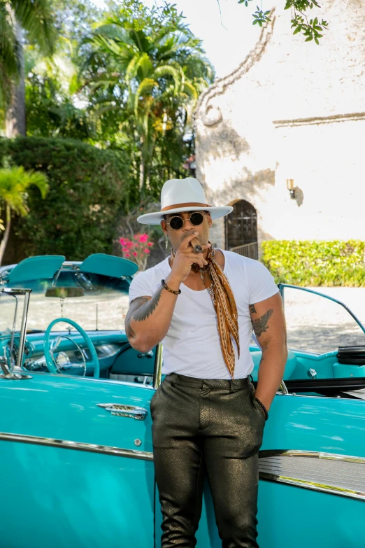 a man standing in front of a vintage car