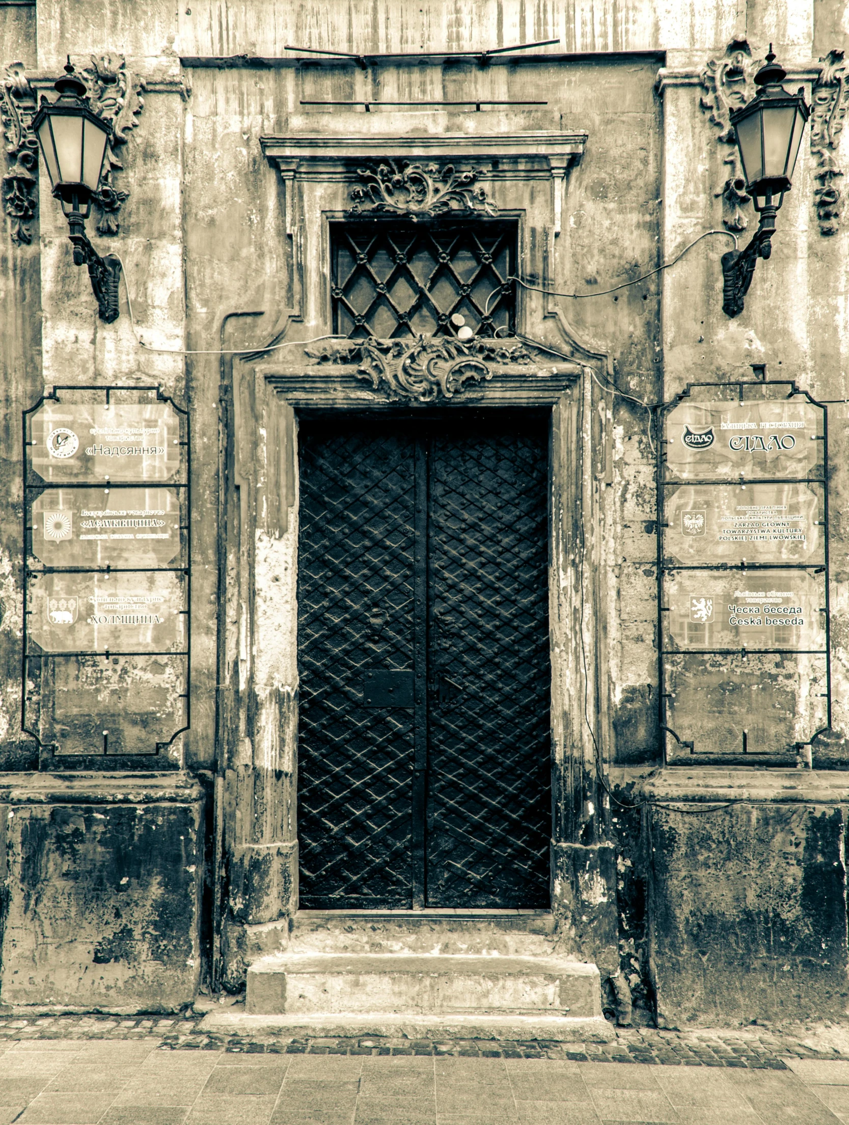 a black and white photo of an old building, an album cover, by Adam Marczyński, pexels contest winner, baroque, door, sepia colors, naples, 1999 photograph