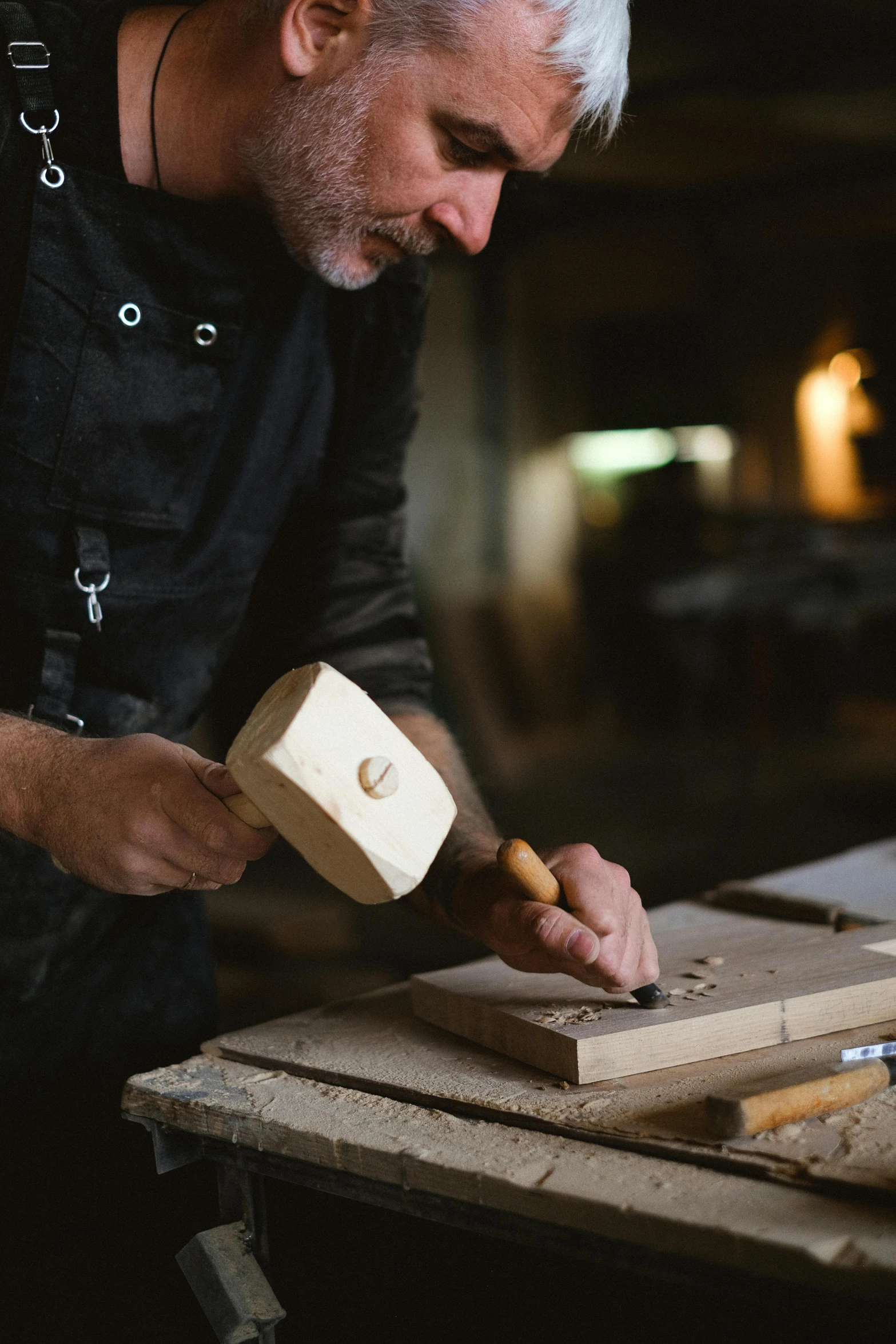 a man working on a piece of wood with a mallet, inspired by Constantin Hansen, trending on pexels, arts and crafts movement, dwell, bustling, plating, australian