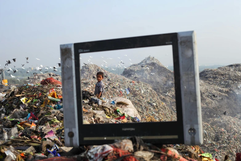 a tv sitting in a pile of garbage and birds in the sky