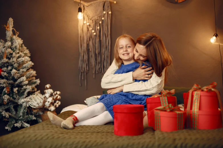 a  sitting on her mother's lap with christmas presents around her