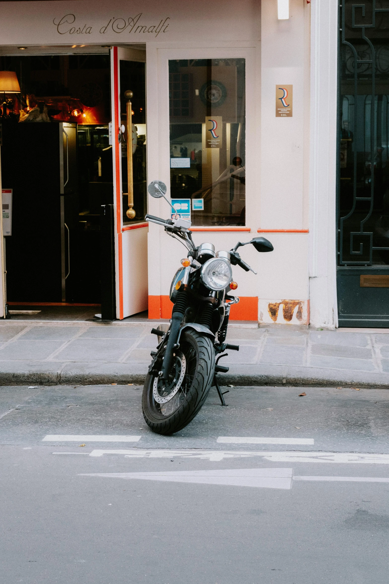 a motorcycle parked on the side of a street, by Daniel Seghers, pexels contest winner, inside a french cafe, 🚿🗝📝