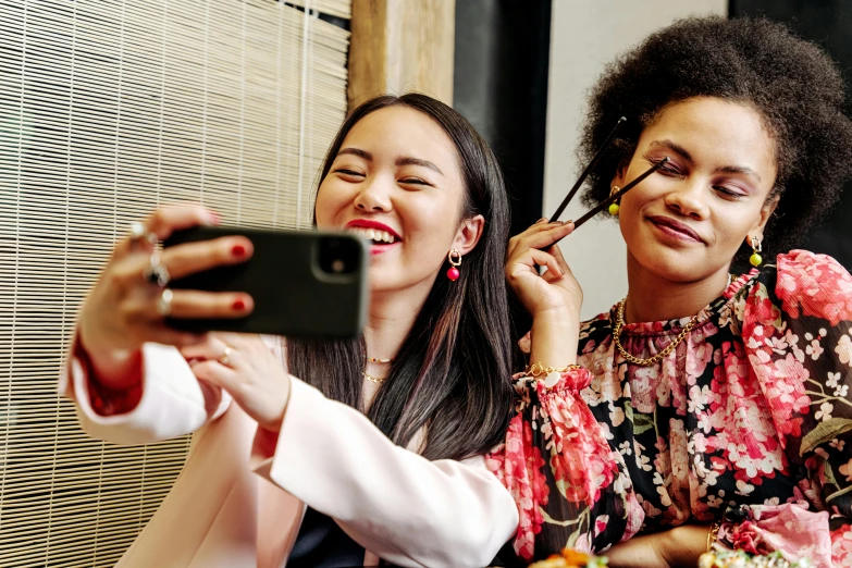 two women sitting on a couch taking a selfie, trending on pexels, popular korean makeup, avatar image, diverse, graphic print