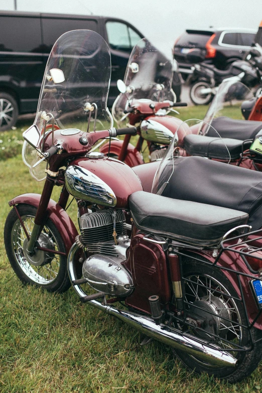 a group of motorcycles parked next to each other, a colorized photo, unsplash, maroon, german, on display, close up details