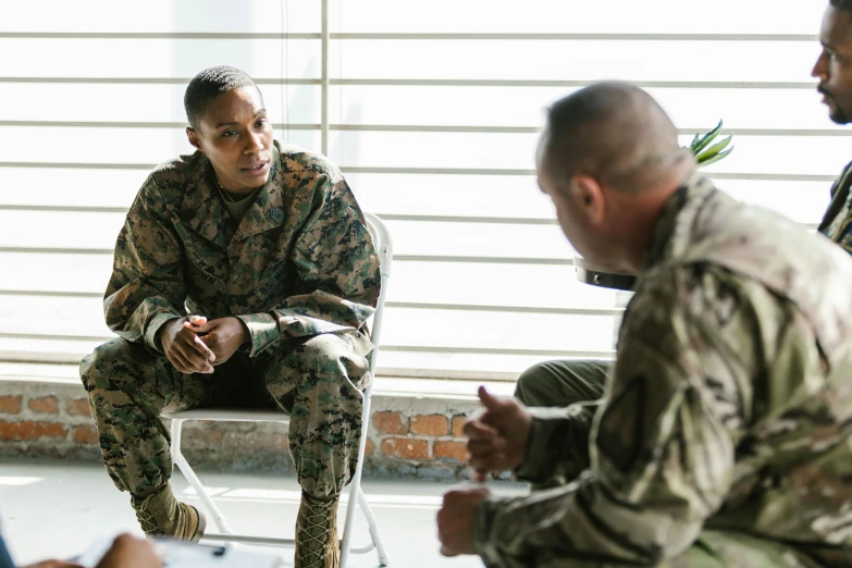 a group of military men sitting around each other, pexels, mental health, medium shot of two characters, wearing camo, talking