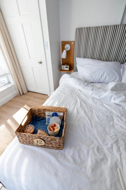 a basket filled with breakfast and juice sits on top of the bed