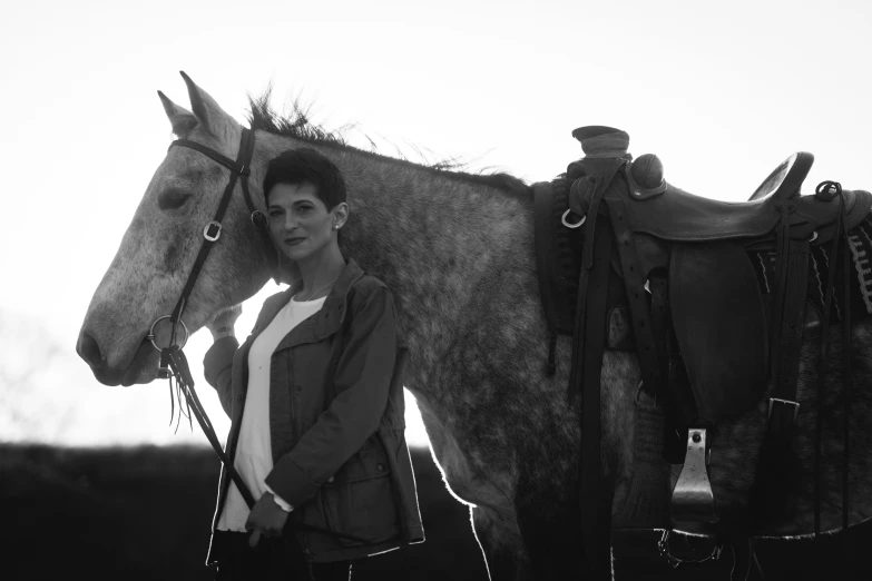 a woman standing next to a horse in a field, a black and white photo, shohreh aghdashloo, wearing farm clothes, pr shoot, jamel shabbaz