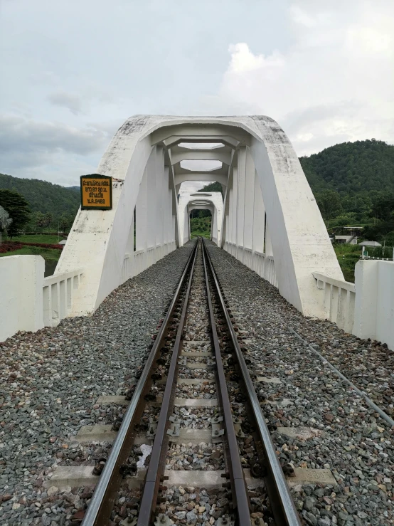 a rail road crossing under a cloudy sky