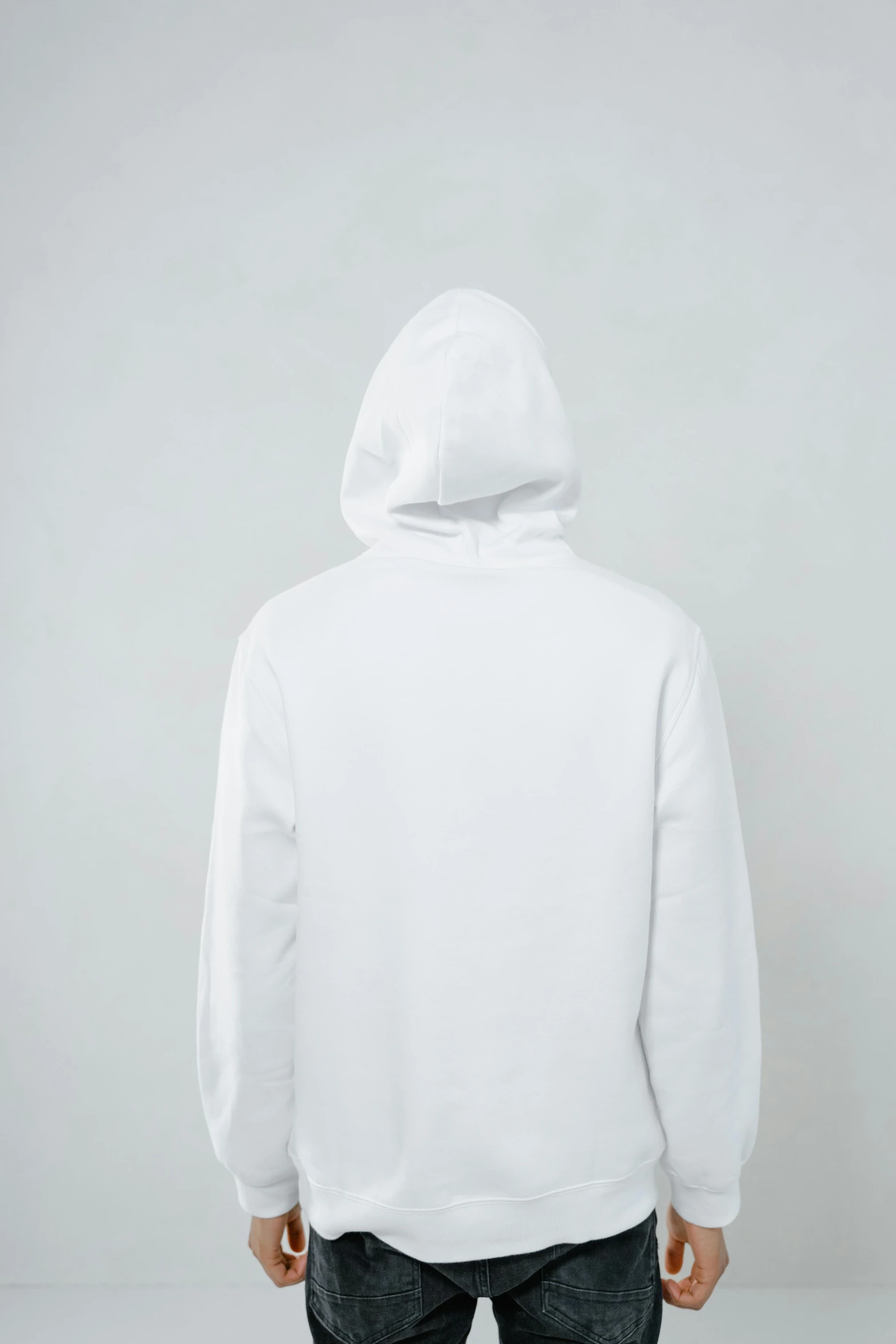 a man in a white hoodie standing with his back to the camera, unsplash, minimalism, detailed product image, ignant, clothing photography, white pearlescent