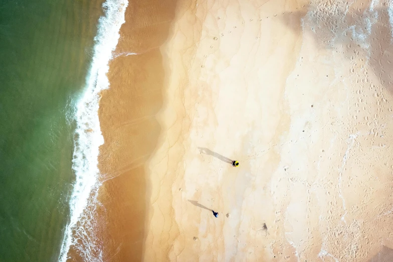 a couple of people standing on top of a sandy beach, unsplash contest winner, minimalism, bird\'s eye view, manly, yellow, drop shadow