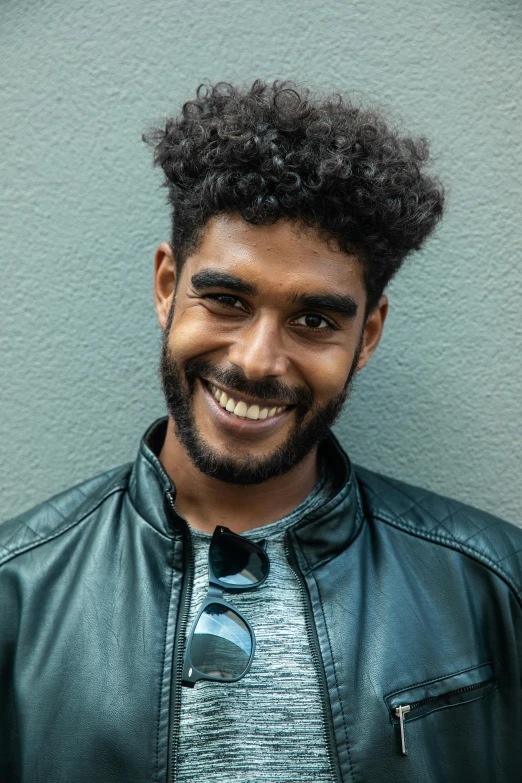 a close up of a person wearing a leather jacket, pexels contest winner, renaissance, brown skin man with a giant grin, curly middle part haircut, 2 4 - year - old man, dark grey haired man