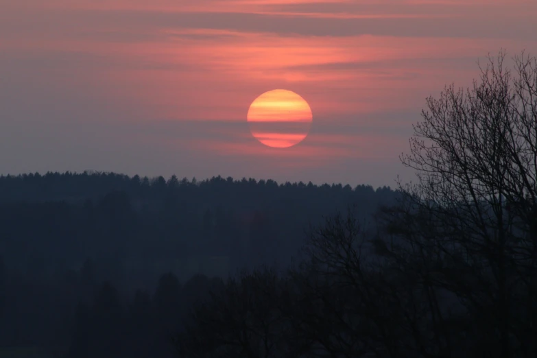 a red and orange sun setting behind the mountains