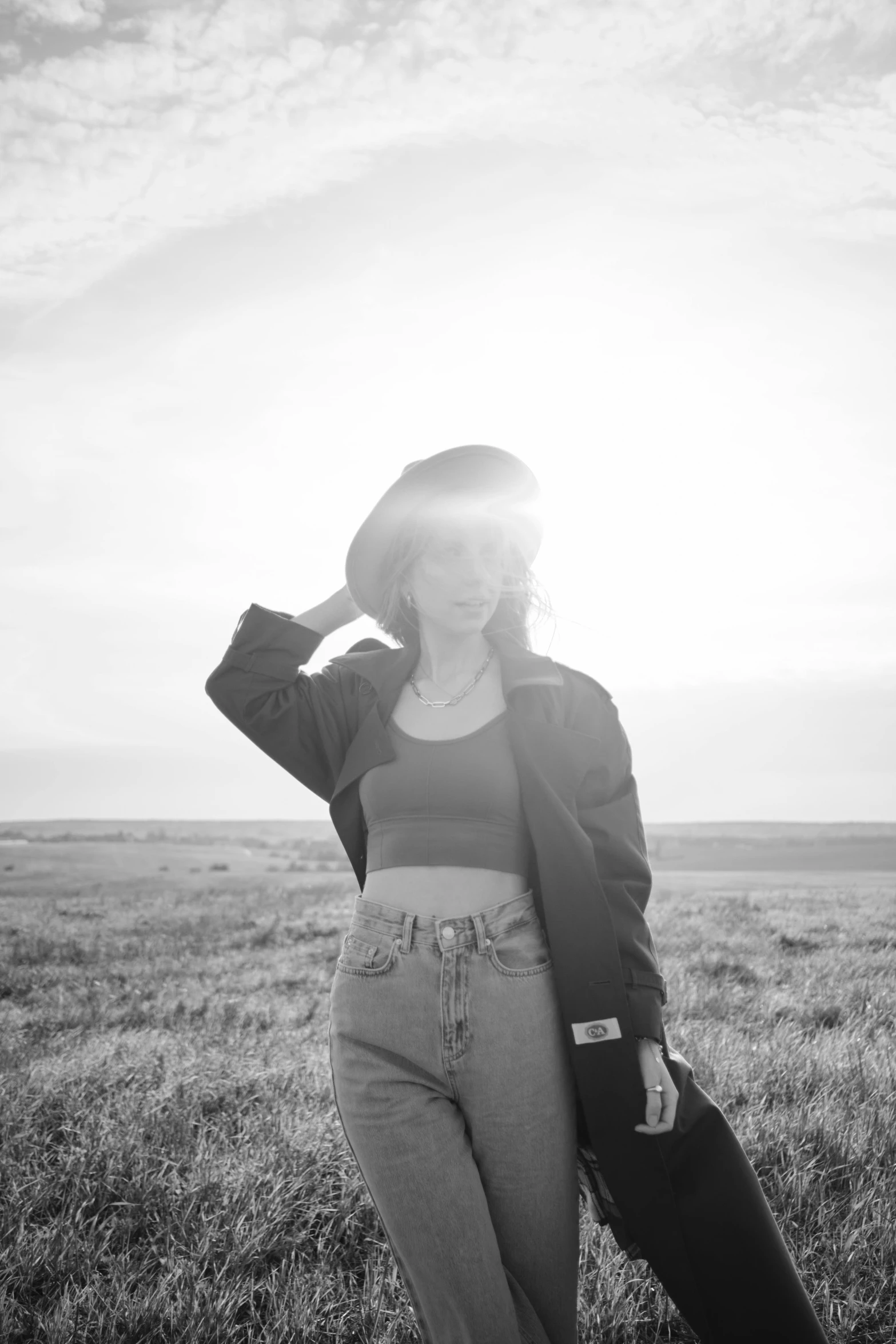 a young woman standing in a field of grass