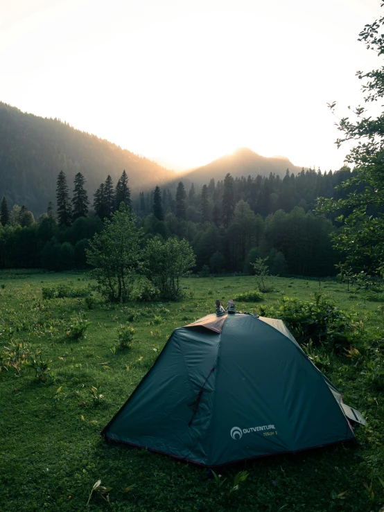 a green tent sitting on top of a lush green field, sun rises between two mountains, daverapoza, he is at camp, album