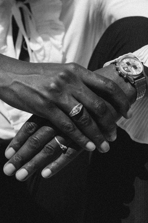 a black and white photo of a man with a watch on his wrist, inspired by Gordon Parks, holding each other hands, young thug, an elegant couple, large)}]