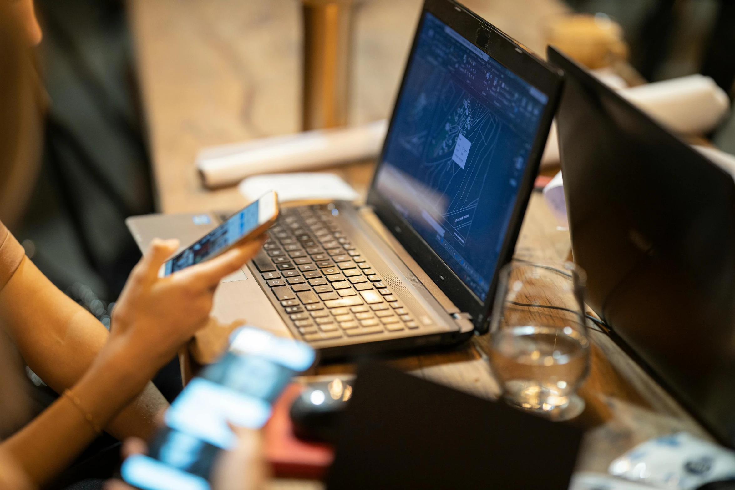 a woman sitting at a table using a laptop computer, by Joseph Severn, unsplash, happening, checking her phone, brass equipment and computers, official screenshot, networking