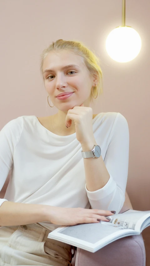 a woman that is sitting down with a book, wearing a watch, olya bossak, round-cropped, scandinavian design