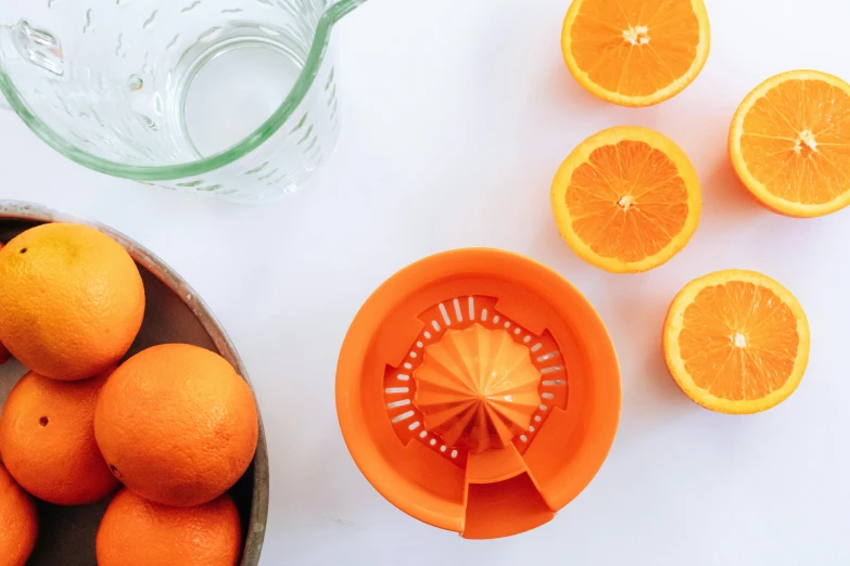 a bowl of oranges next to an orange juicer, by Carey Morris, trending on unsplash, dividing it into nine quarters, epicurious, close-up product photo, filling with water