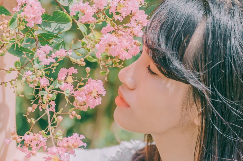 a woman holding a pink flower in front of her face, a picture, by Tan Ting-pho, trending on pexels, aestheticism, with soft bushes, aoi ogata, looking off to the side, made of flowers and leaves