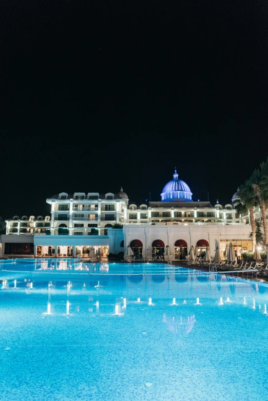 a large swimming pool surrounded by palm trees, renaissance, at night, jerez, profile image