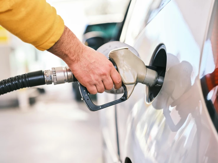 a person pumping gas into a car at a gas station, shutterstock, photorealism, australian, square, 1 petapixel image, extremely high resolution