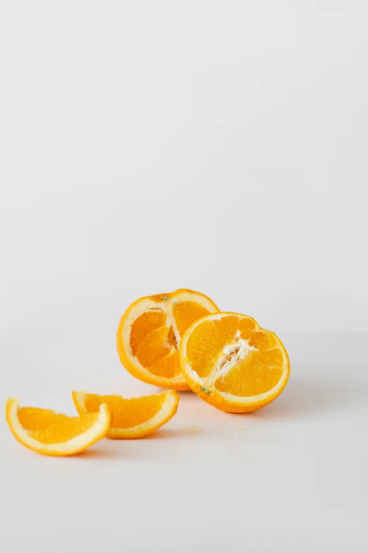 an orange cut in half on a white surface, by Mandy Jurgens, reddit, on a gray background, dynamic angled shot, “organic, natural soft rim light
