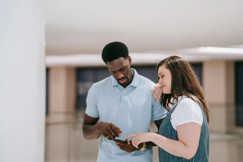 a man and a woman looking at a cell phone, at behance, mkbhd, very very low quality picture, uk