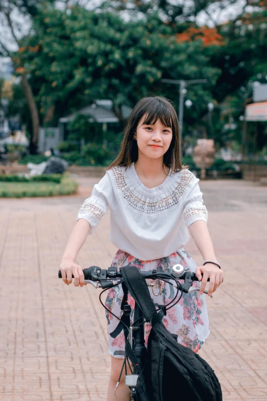 a woman riding a bike on a brick road, by Tan Ting-pho, pexels contest winner, realism, cute young girl, 🤤 girl portrait, long sleeves, friendly face