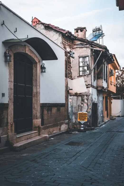 a street sign sits in front of buildings with broken windows